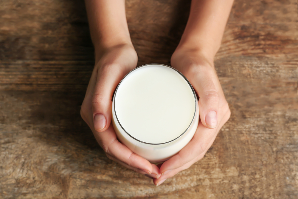 hands holding a glass of milk - aeriel view